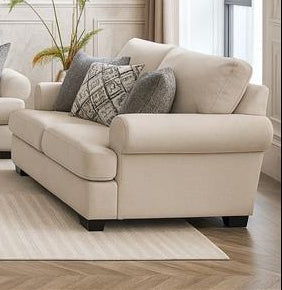 Modern living room with beige sofa set and decorative elements.